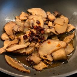Frying shiitake, onions, and garlic in Szechuan sauce and chilli oil