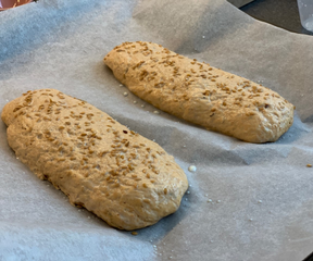 Mini baguettes made from herb bread topped with golden flaxseed